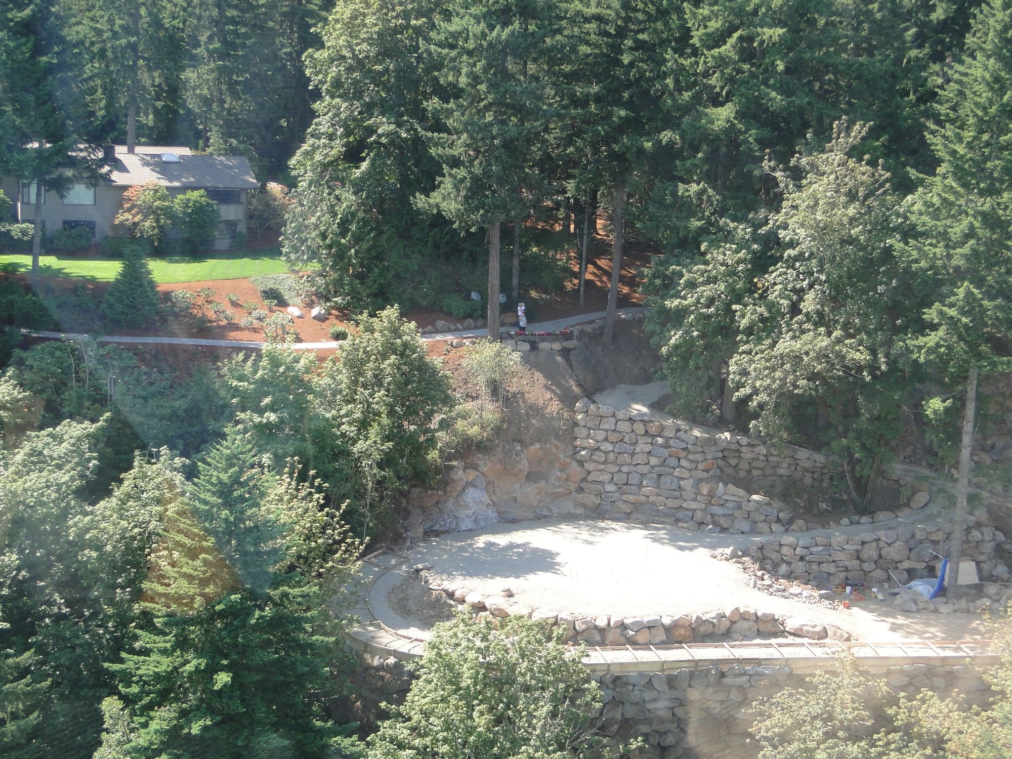 Hillside stone wall construction aerial
