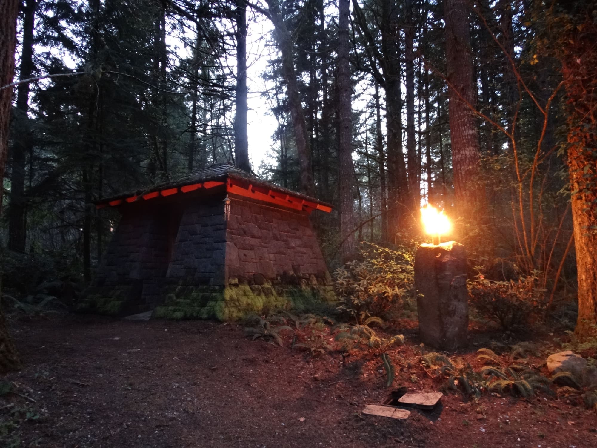 Stone hut torch flame dusk